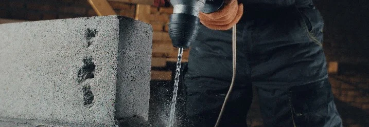 Bohrmaschine bohrt in Betonblock